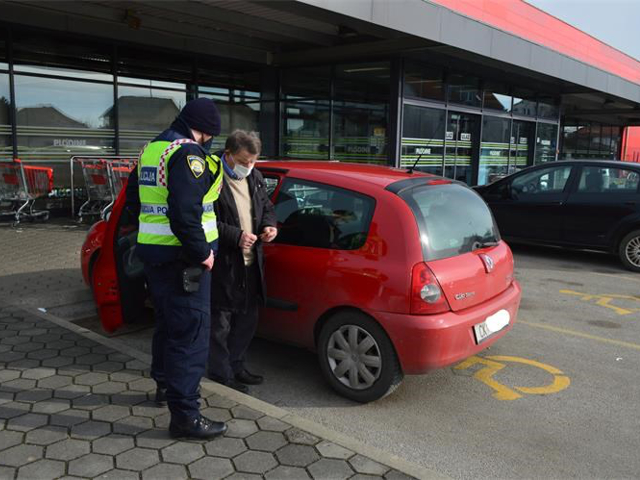 Policajac i čovjek nepropisno parkiran na mjestu za osobe s invaliditetom.